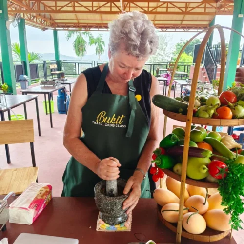 Guest making traditional Thai curry paste during a cooking class in Phuket. The curry paste is from Chef's originate recipe from his hometown.