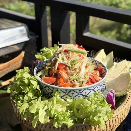 Fresh, fiery, and full of crunch! A beautifully presented bowl of Som Tum (Green Papaya Salad) made with vibrant Thai ingredients. Taste the real spicy-sour magic at Bukit Thai Cooking Class Phuket Thailand!